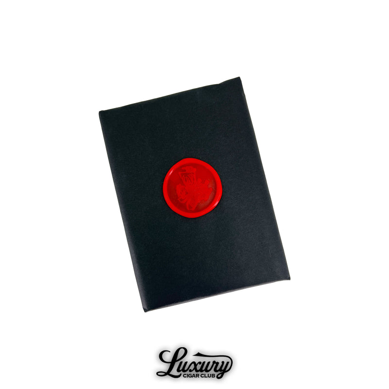 Closed black paper bundle of Stolen Throne Crook of the Crown Robusto cigars sealed with a red wax stamp featuring the brand logo from Luxury Cigar Club.