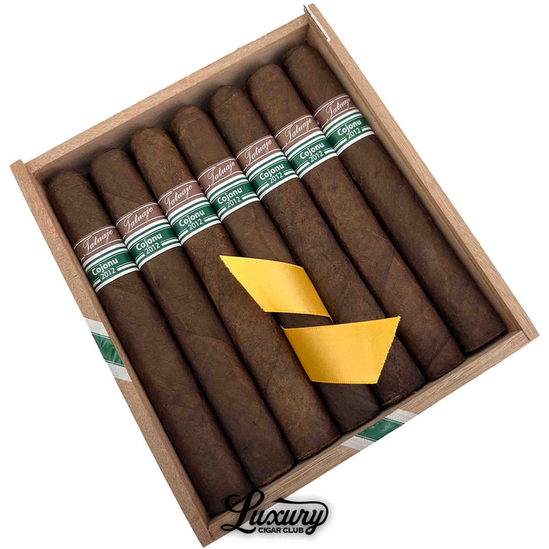 Close up view of Tatuaje Cojonu 2012 Tuxtla cigars in open box with yellow ribbon at Luxury Cigar Club