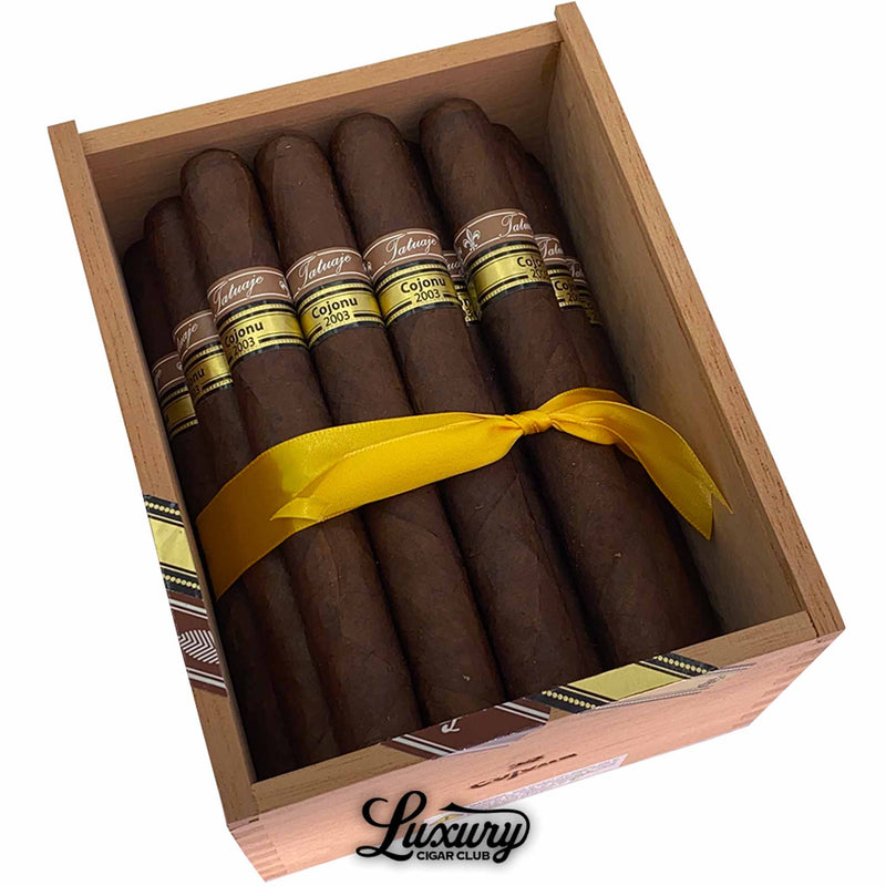 Close-up of open box Tatuaje Miami Cojonu 2003 cigars tied with yellow ribbon and Luxury Cigar Club logo