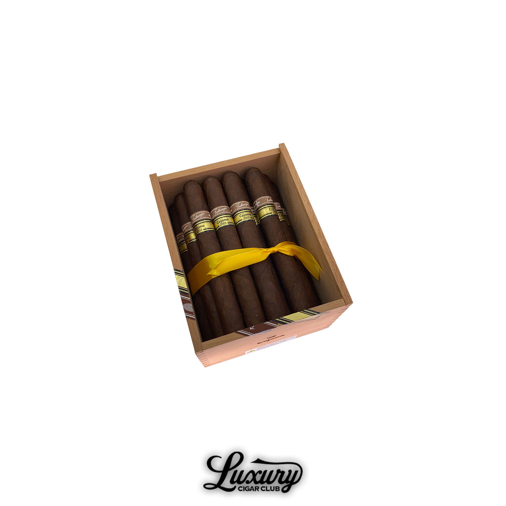 Open box of Tatuaje Miami Cojonu 2003 cigars with yellow ribbon and Luxury Cigar Club logo