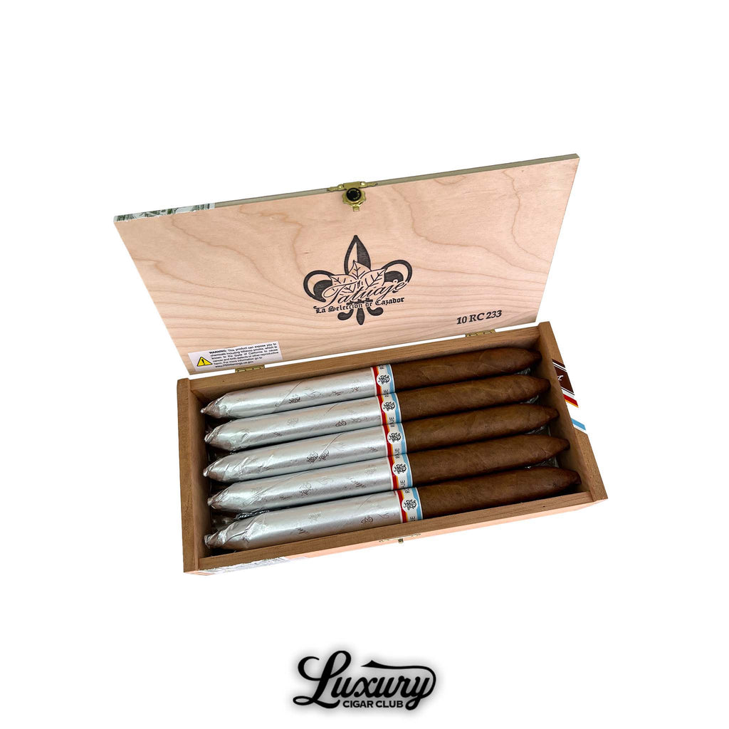 Open box of Tatuaje RC 233 Gran Perfecto cigars from Luxury Cigar Club showing ten premium cigars half wrapped in silver foil and half bare inside a natural wood box with the Tatuaje logo.