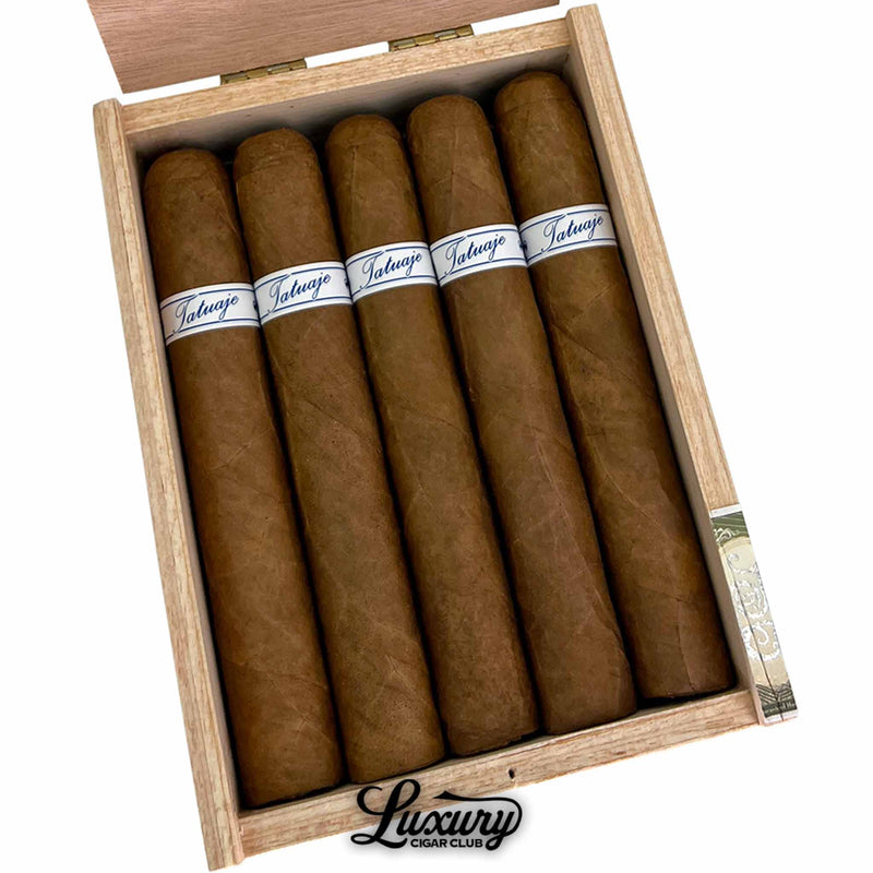 Close up inside wooden box of Tatuaje Series P Honduras Short Toro cigars, medium brown wrapper shade, white and blue Tatuaje bands clearly visible, Luxury Cigar Club branding under box.