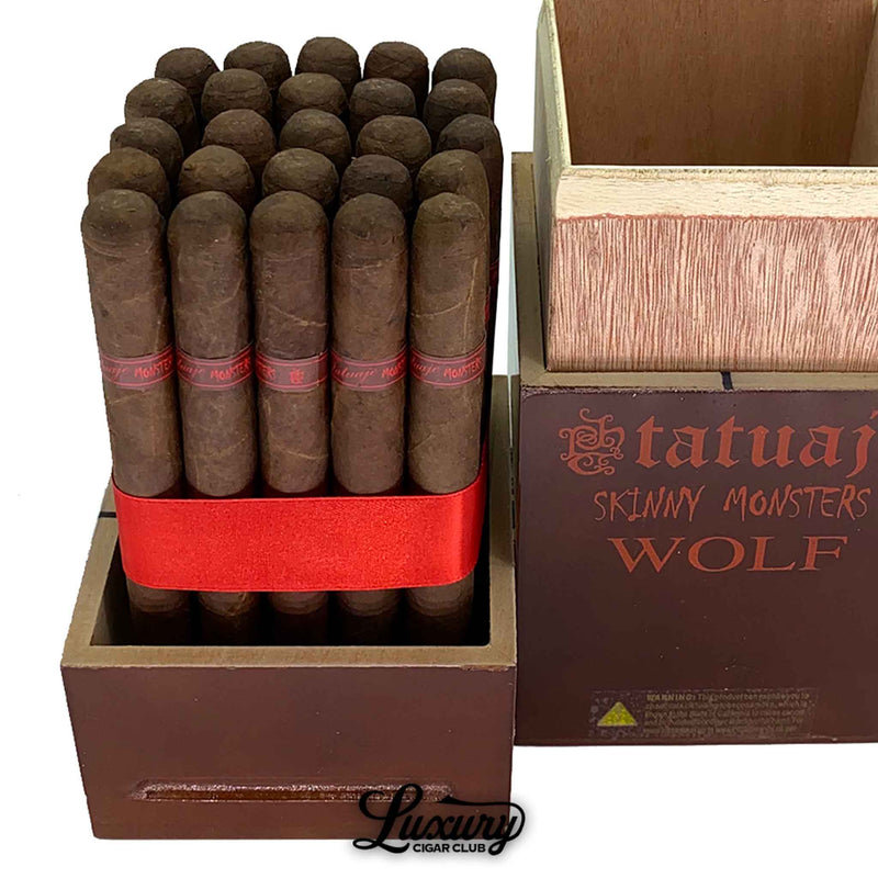 Close up view of Tatuaje Skinny Monsters Wolf cigars arranged in a tight bundle with red ribbon inside the brown monster series box showing band details and wood grain texture for Luxury Cigar Club.