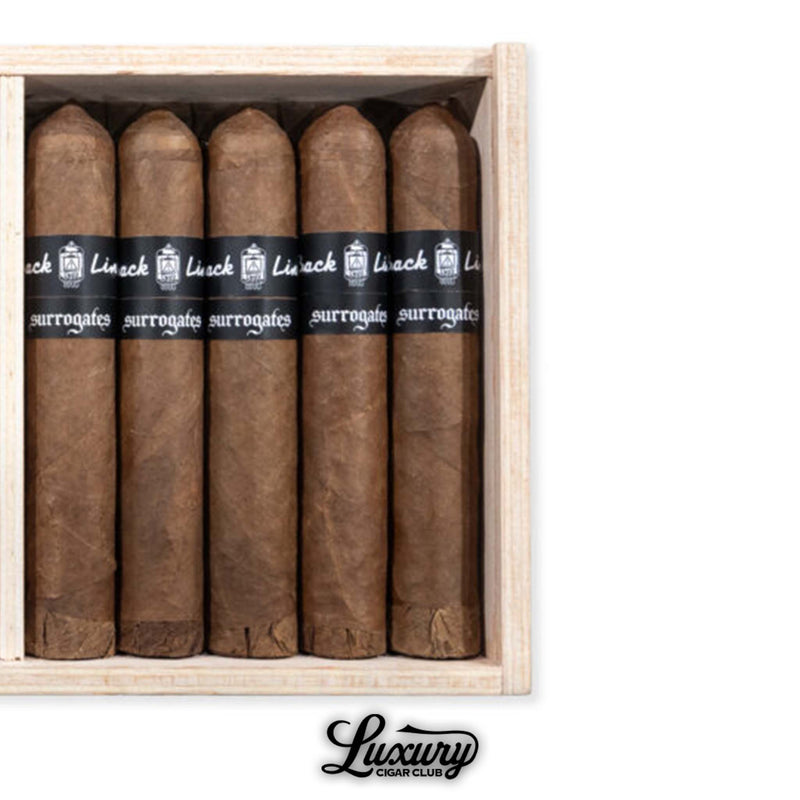 Close-up of Tatuaje Surrogates Back Line EL554 cigars arranged in a wooden box from Luxury Cigar Club.