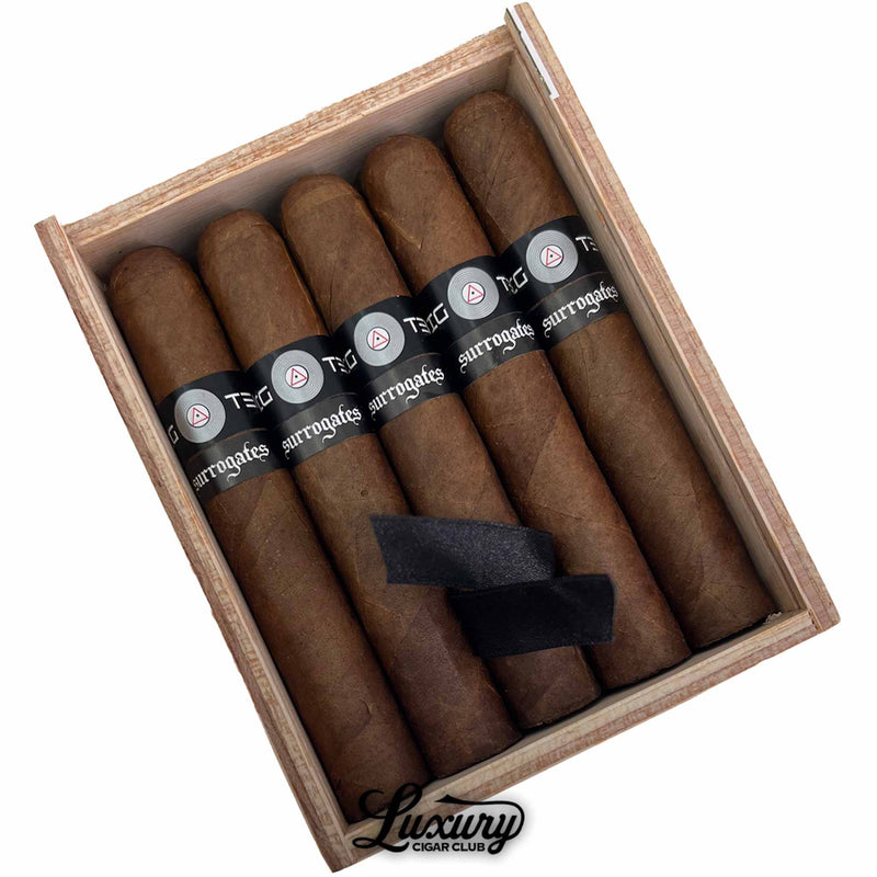 Close-up detail of Tatuaje Surrogates Big Ten Robusto cigars in open wooden box showing rich brown wrappers and black Surrogates bands, for Luxury Cigar Club online store.