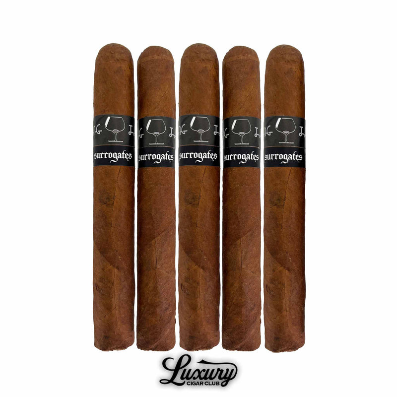 A 5 pack of Tatuaje Surrogates Closing Time Toro cigars standing vertically with dark bands displaying cocktail glass artwork on a white background, Luxury Cigar Club logo below.
