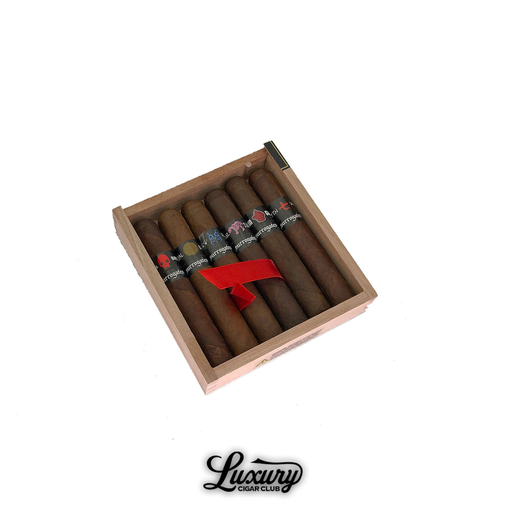 Tatuaje Surrogates Sampler Robusto Exclusivos box featuring six premium cigars with distinct band designs, presented by Luxury Cigar Club.
