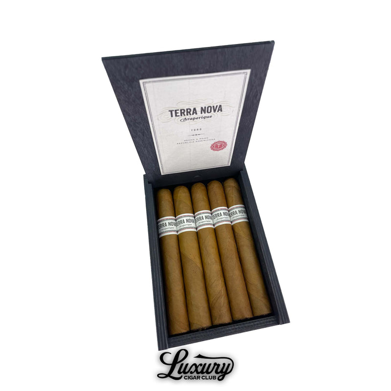 Open black box of Terra Nova Araperique Toro cigars with five cigars neatly arranged inside. The box lid features a white Terra Nova Araperique label with red seal, and cigars display tan wrappers and white bands. Luxury Cigar Club logo below.