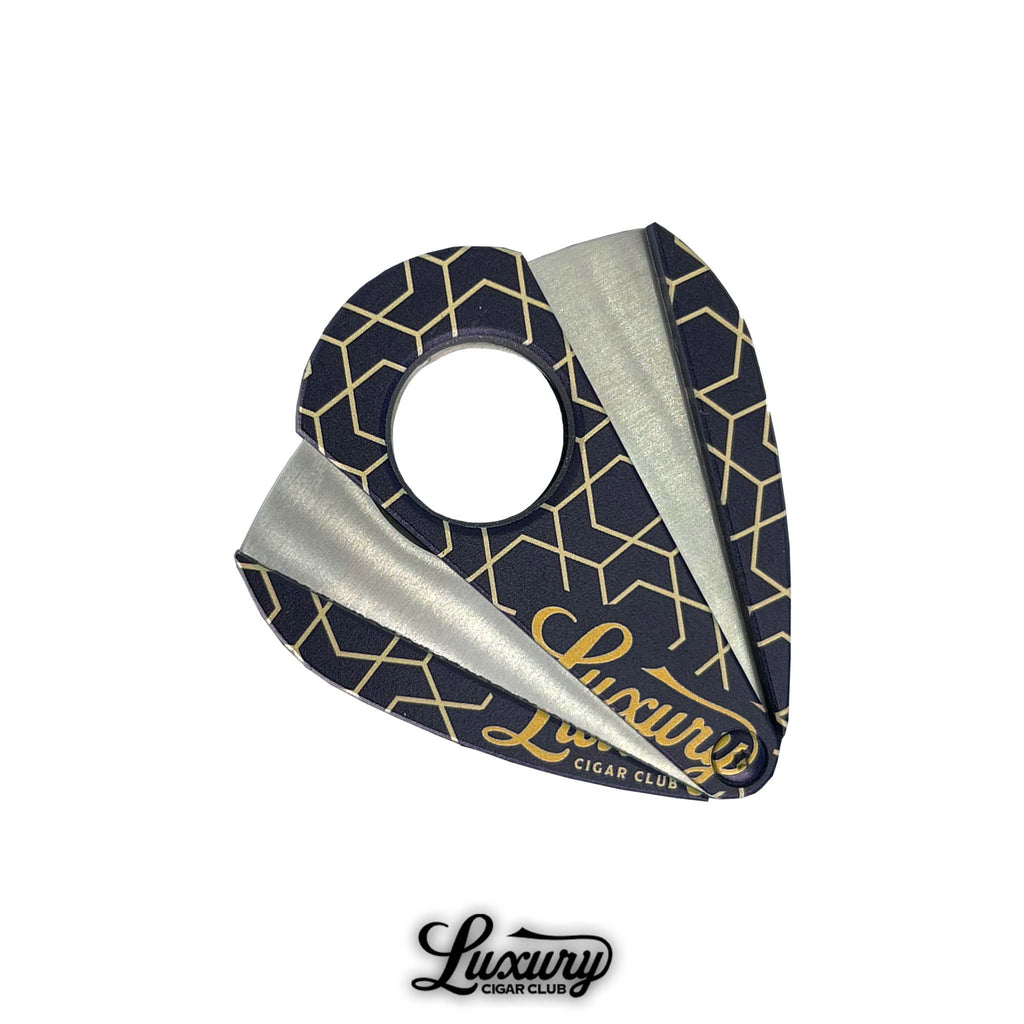 Premium guillotine cigar cutter with geometric gold pattern on navy body.