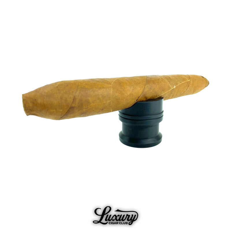 Matte black Zimmer Maverick cigar rest holding a premium cigar, sleek and modern accessory photographed for Luxury Cigar Club.