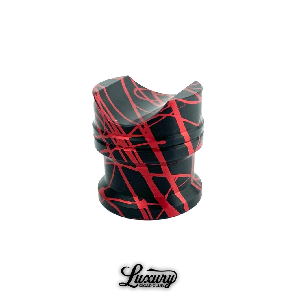 Close up of Zimmer Maverick cigar rest in splashed aluminum finish with red and black pattern, premium cigar accessory from Luxury Cigar Club.