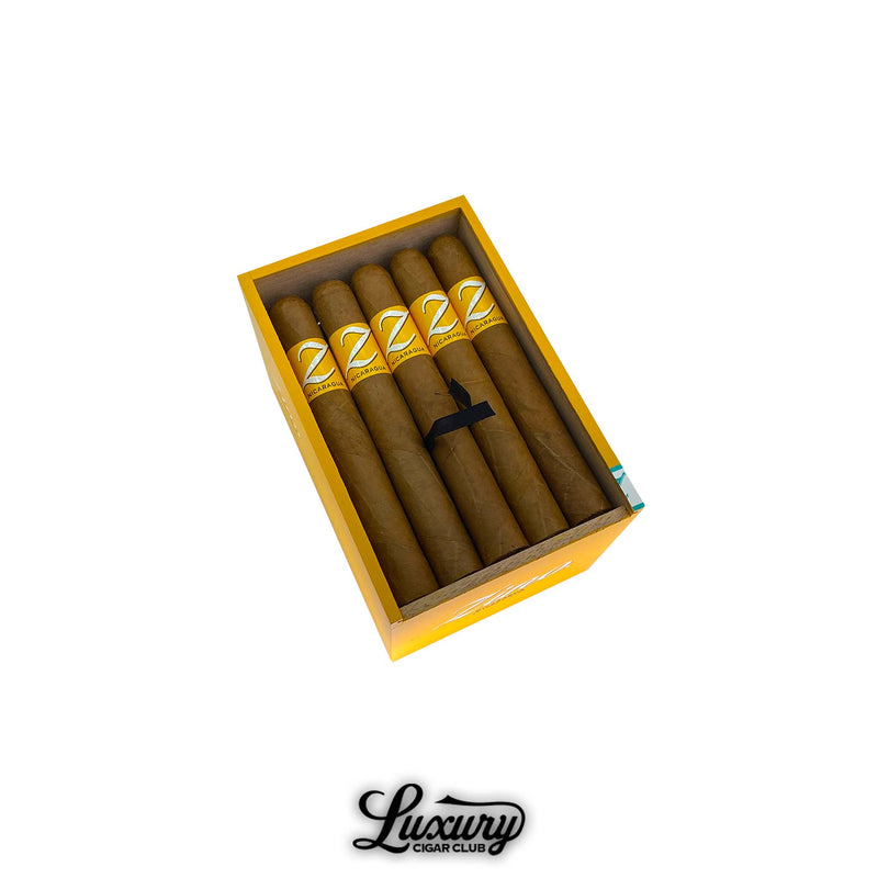 Open box of Zino Nicaragua Toro cigars with golden bands and uniform construction, showcased by Luxury Cigar Club.